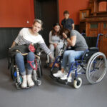 Trzy kobiety na wózku inwalidzkim. Zdjęcie przedstawia szkolenie w ramach programu "Kultura dostępna" dotyczące potrzeb osób z niepełnosprawnością ruchu.